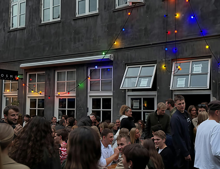 Gæster foran facaden på Vestergade 46 med kulørte lys